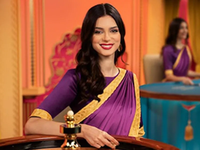 Người chia bài thật đang tương tác với người chơi tại bàn Baccarat trực tuyến, với giao diện hi8823 casino hiển thị trên màn hình.